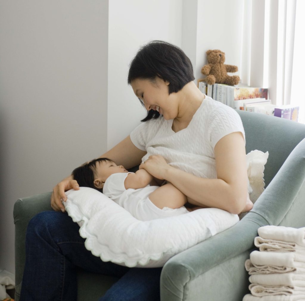Mother breast feeding baby girl